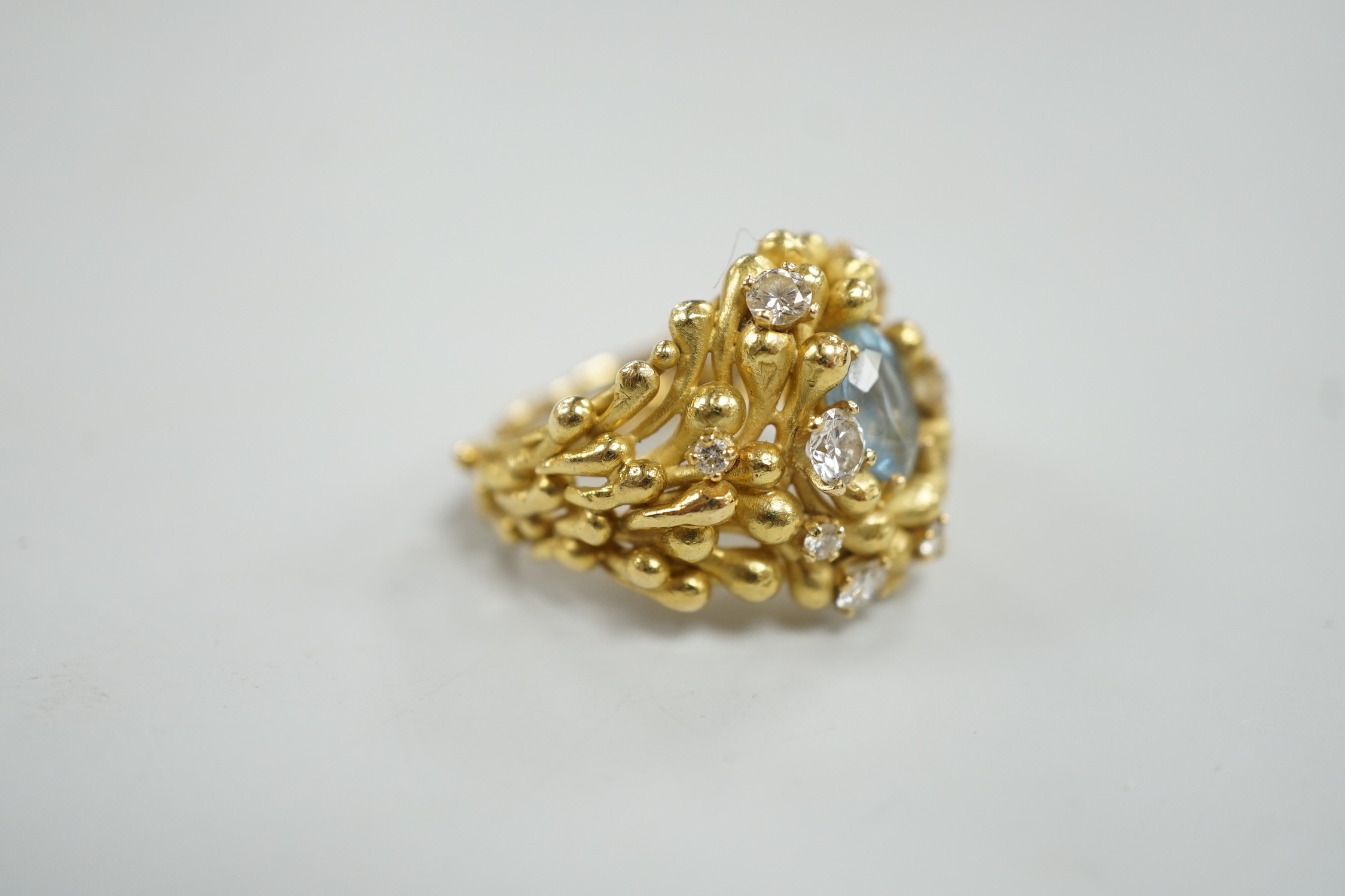 An early 1970's modernist 18ct gold, aquamarine and diamond cluster set dress ring, maker HB or AB? in italics, size O/P, gross weight 16.8 grams.